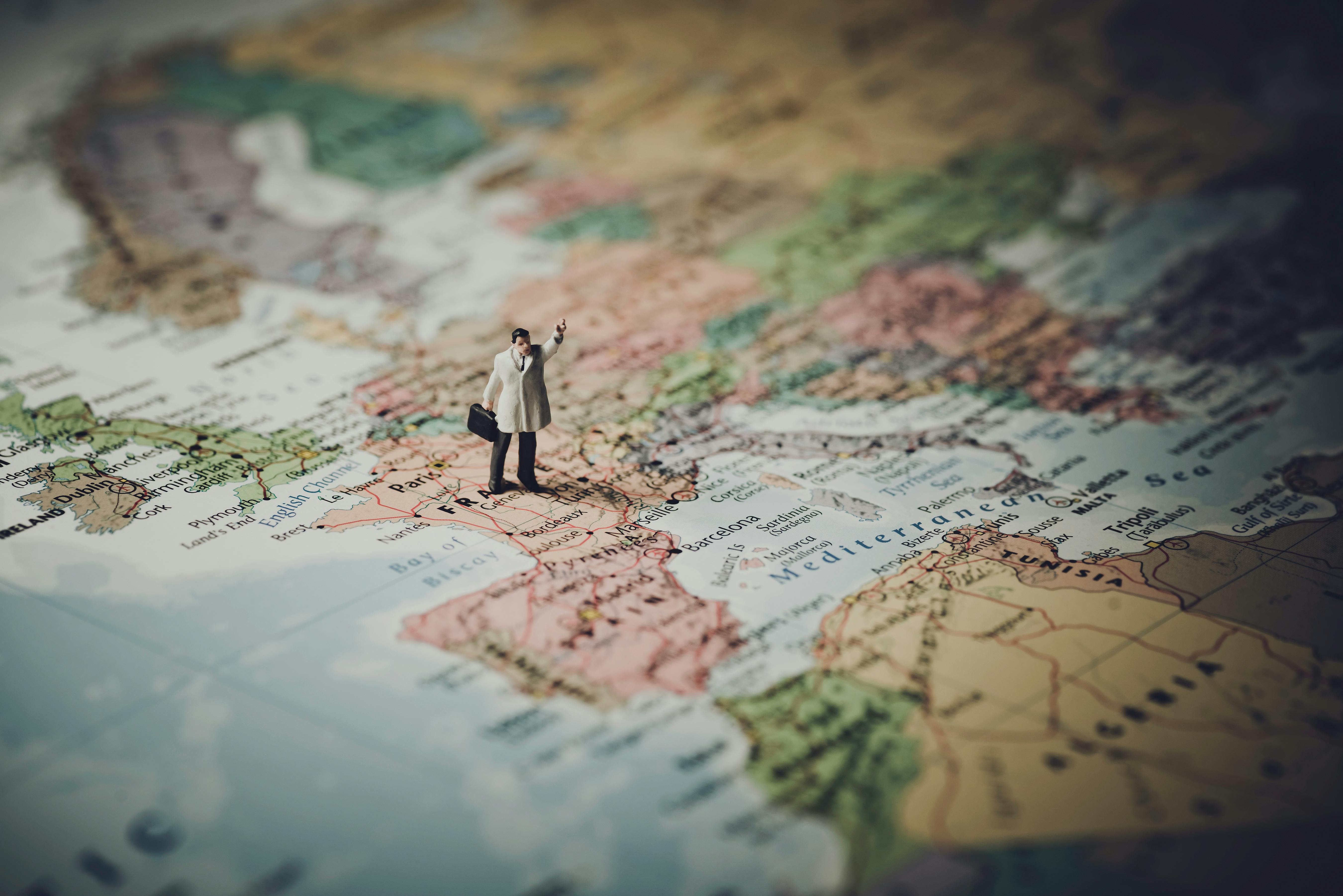 Model Figure Standing On Map Free Stock Photo