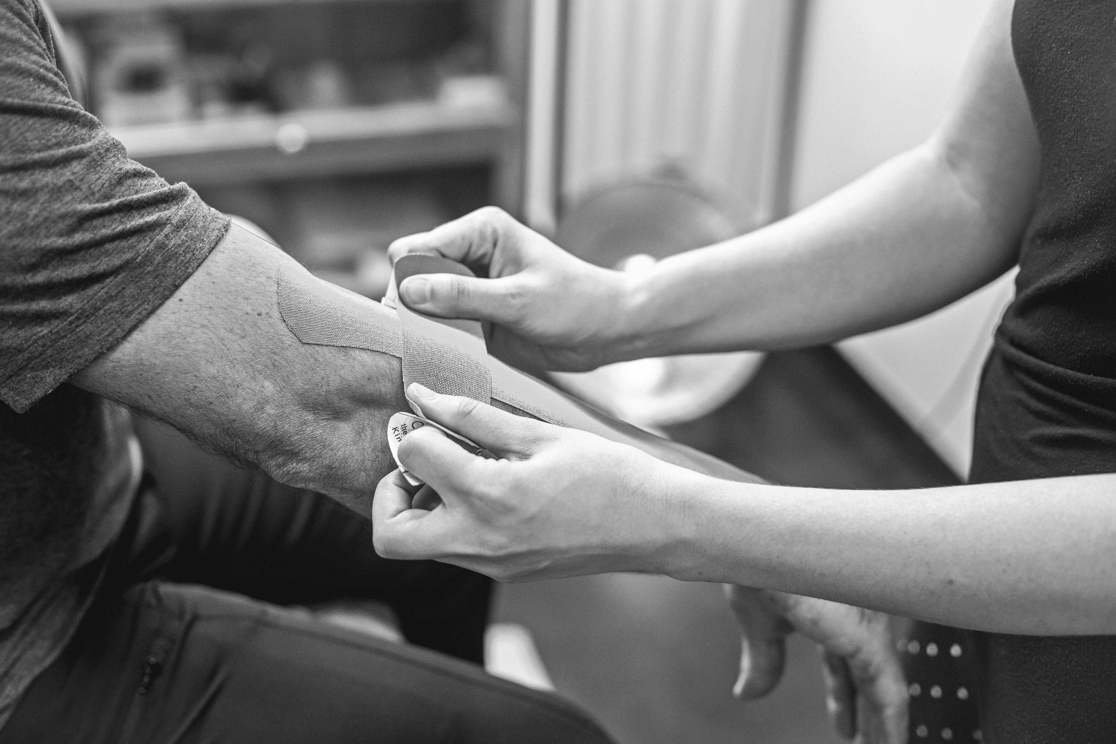 person putting bandage on person s arm