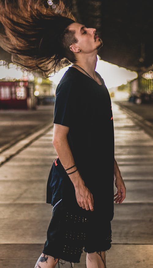 Man in Black T-shirt and Black Skirt on Sidewalk