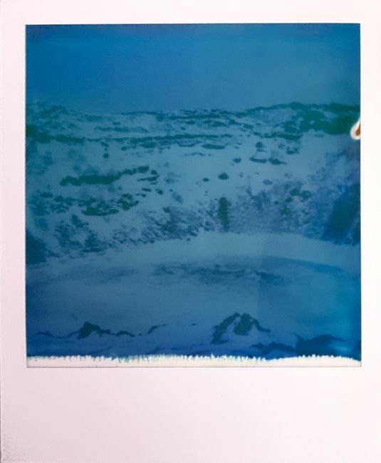 A dreamy vintage Polaroid capturing a snowy mountain scene.