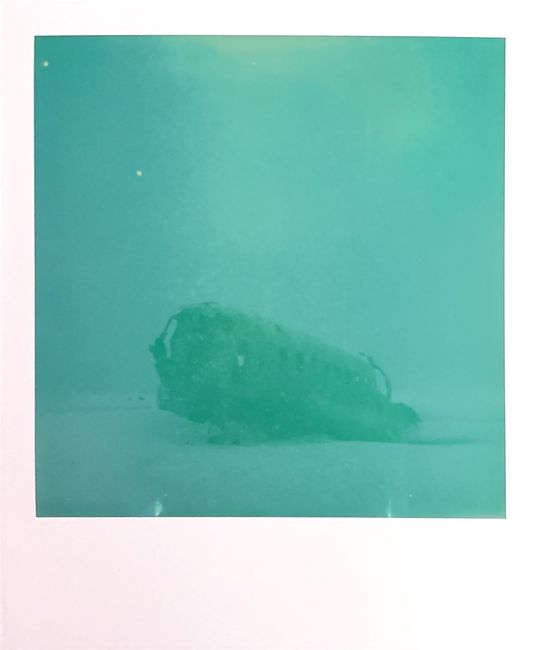 Eerie image of a sunken airplane wreck enveloped in turquoise waters.
