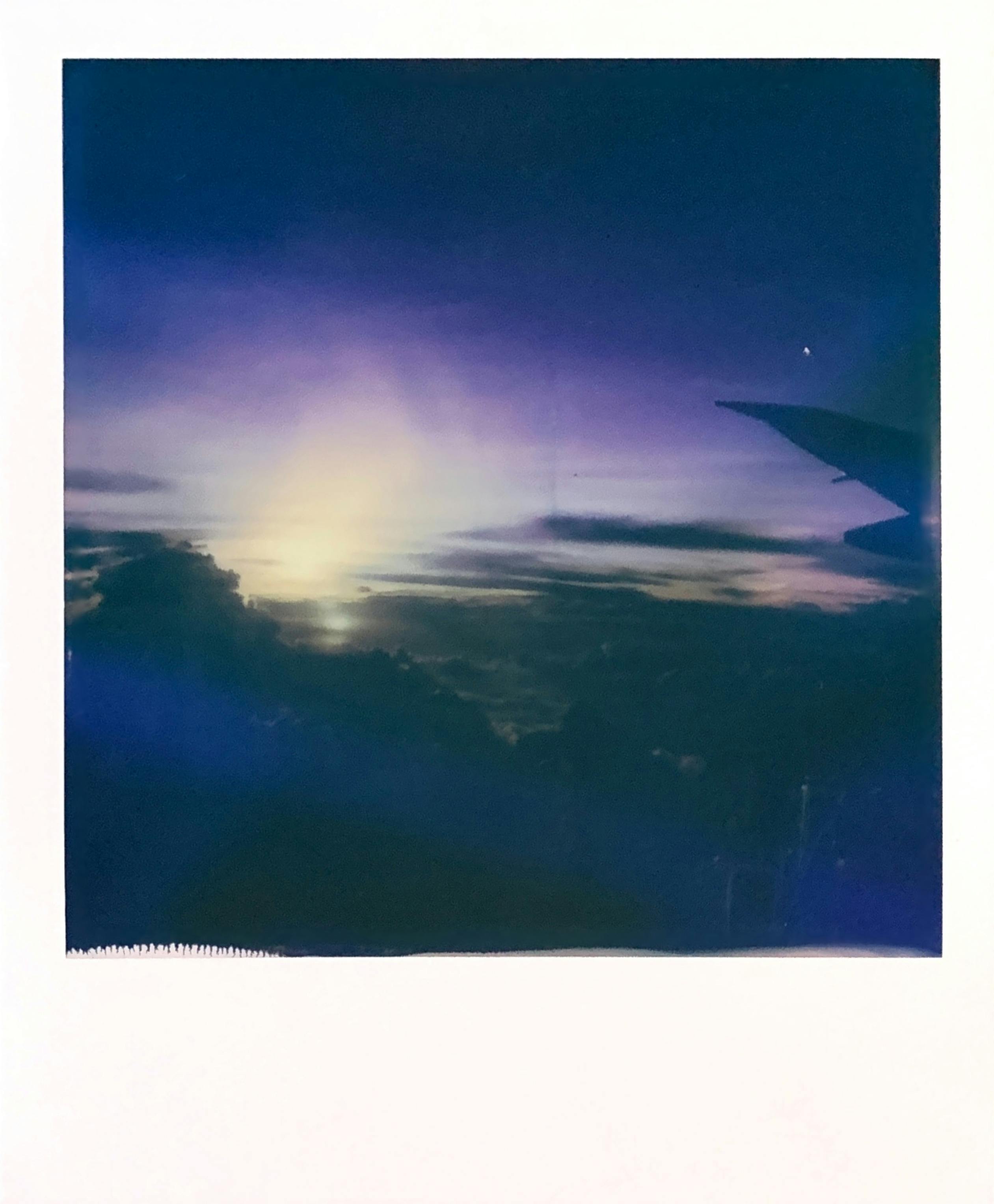 Instant shot of spectacular sea illuminated by sunlight surrounded by mounts under colorful purple sky at sundown at night