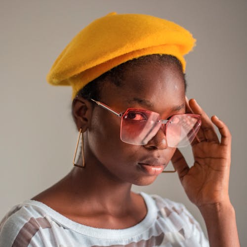 Woman in White Stripe Crew Neck Shirt Wearing Yellow Cap