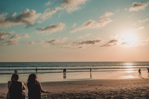 People Enjoying Sunset Over Sea