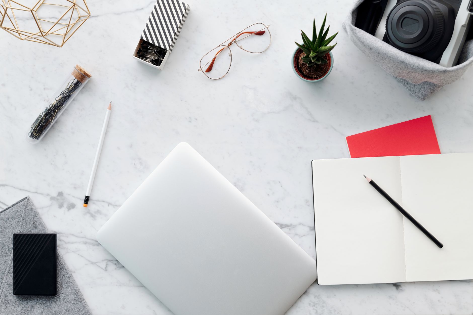 An organized desk with one laptop and a few papers