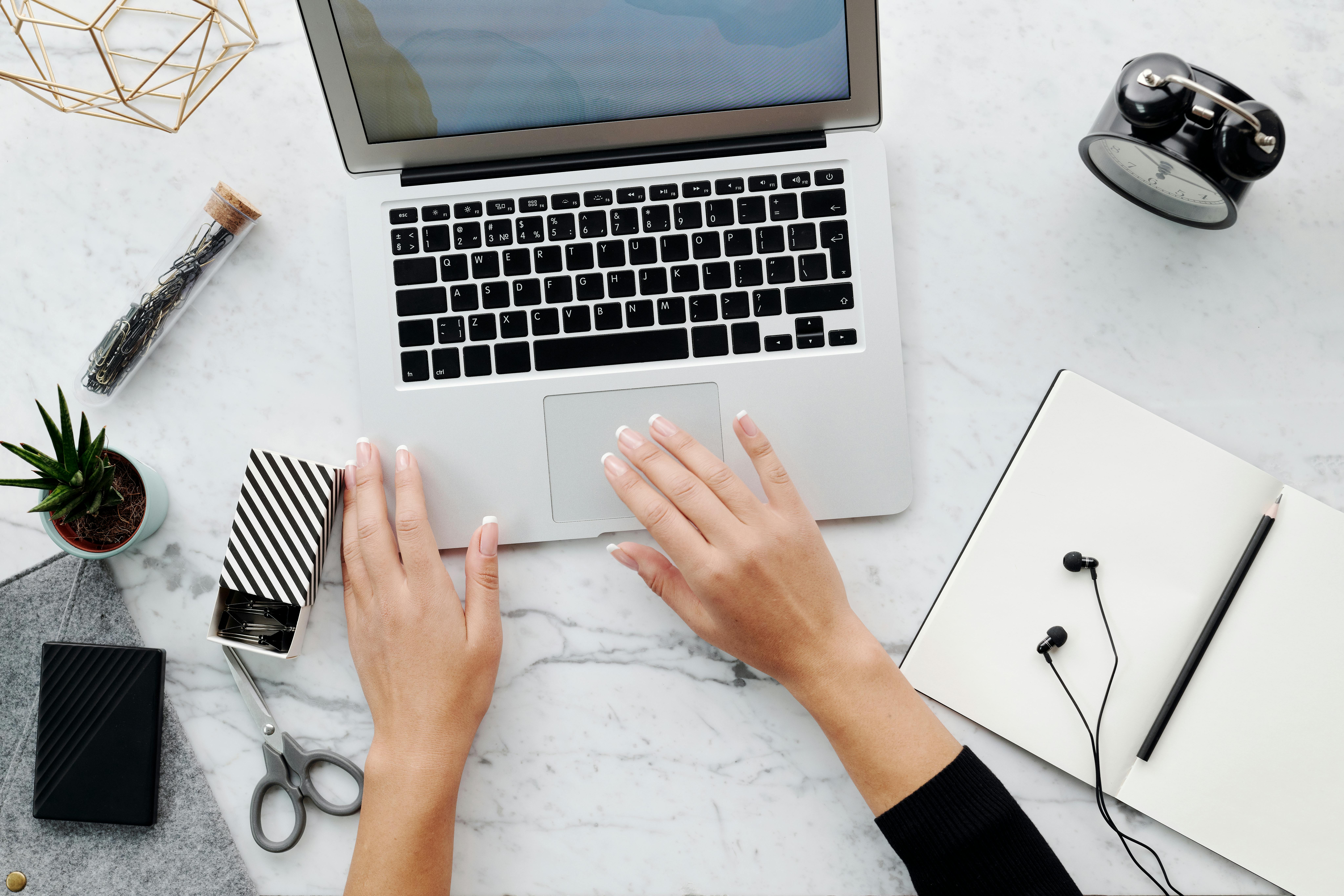 Person Using Macbook Air on White Table · Free Stock Photo
