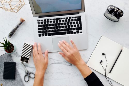 Free High angle view of hands using laptop on marble desk with office and tech accessories. Stock Photo