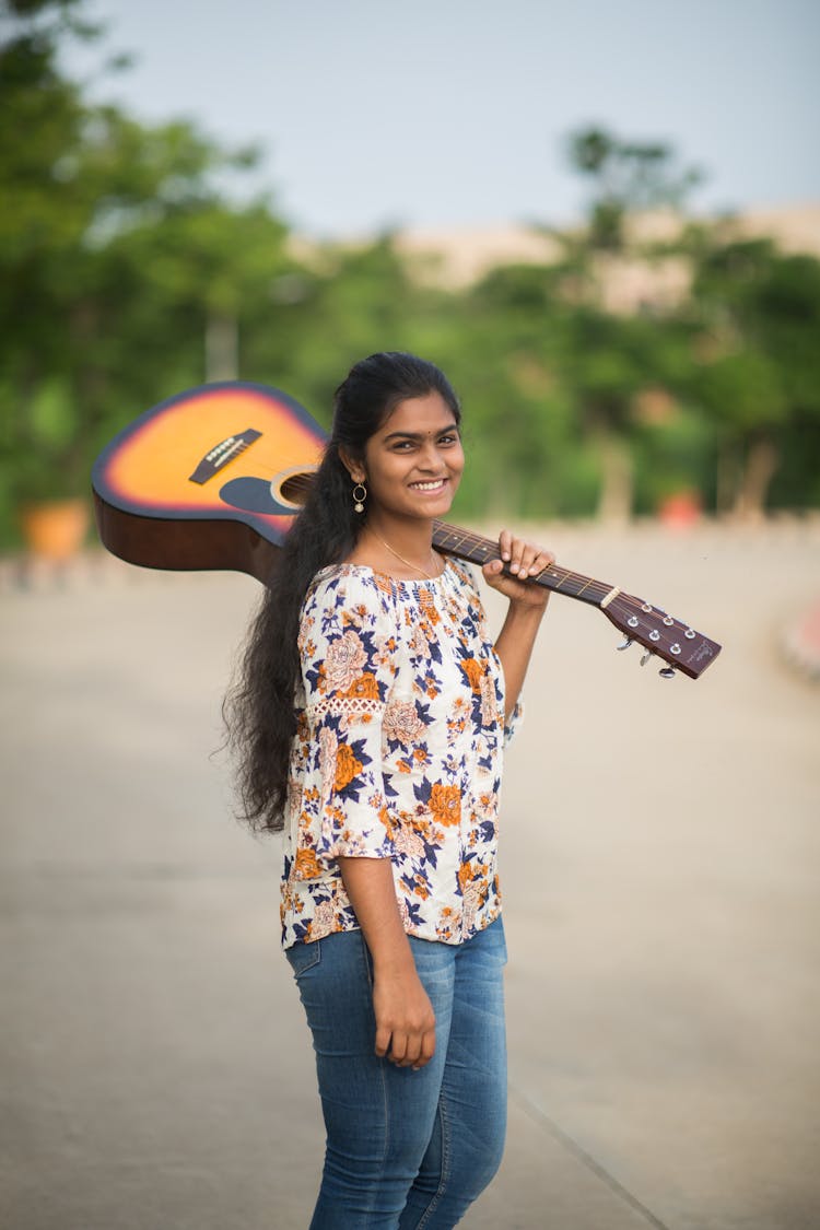 Photo Of A Woman Carrying Acoustic Guitar