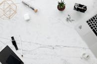 大理石书桌上，一个极简风格的家庭办公区顶视图，展示了小工具和文具用品