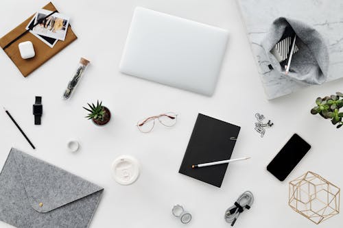 Overhead Shot of Personal Items on a White Surface 