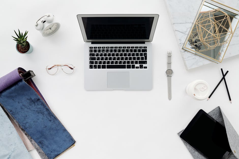 What Sleep Research Reveals About Weighted Blanket Size An organized workspace flat lay featuring a laptop, gadgets, and office essentials on a white surface.