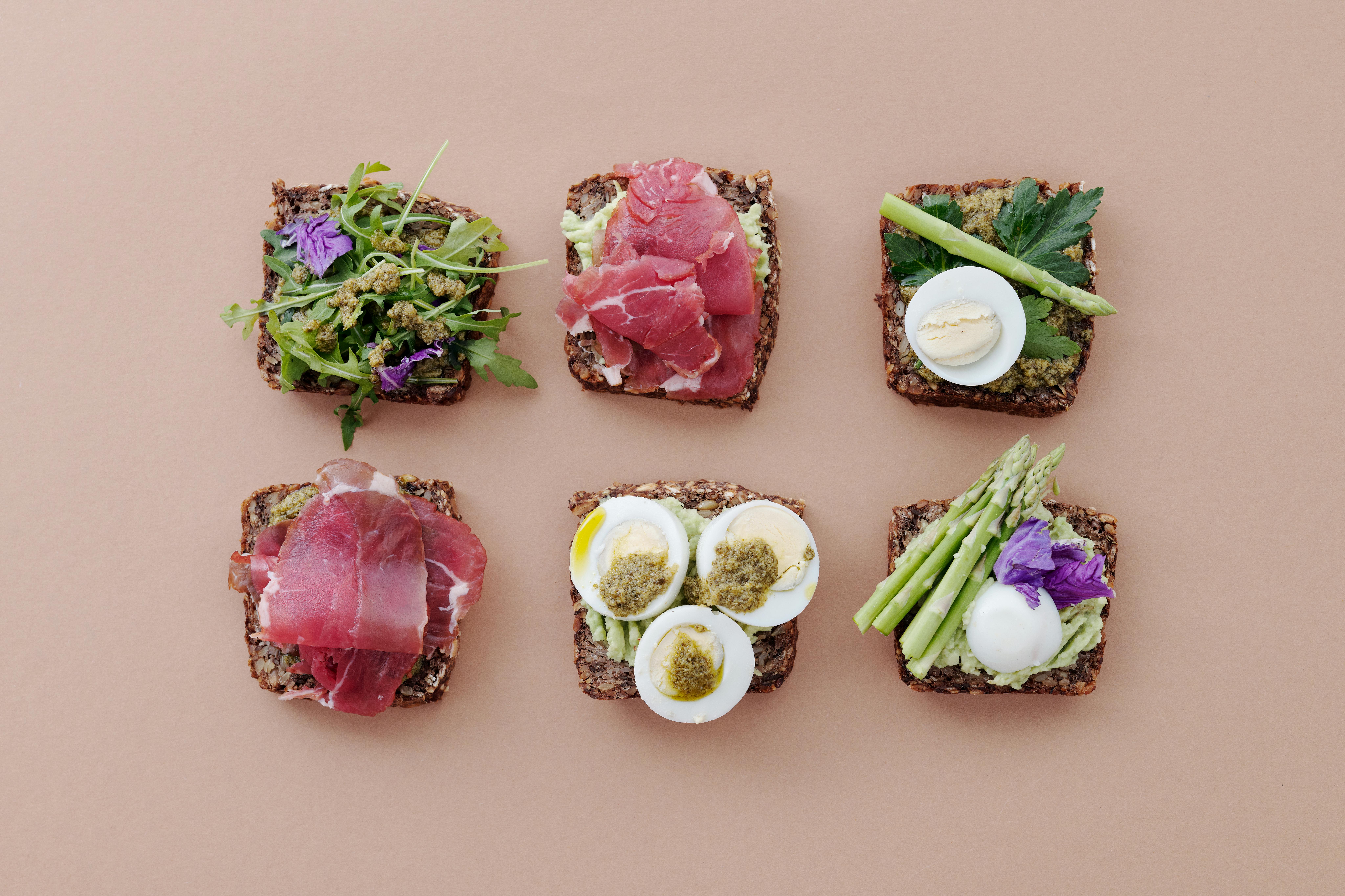 A top view of gourmet sandwiches with fresh ingredients presented in a flat lay style.