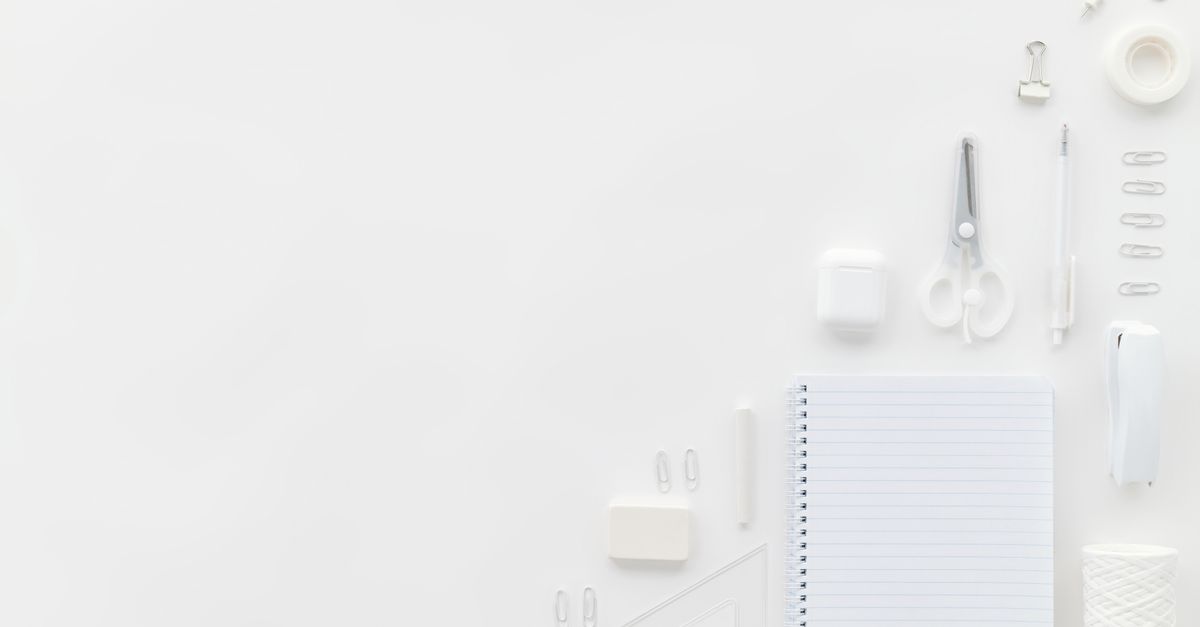 Flat lay of white stationary items on a minimalist office desk with ample copy space.