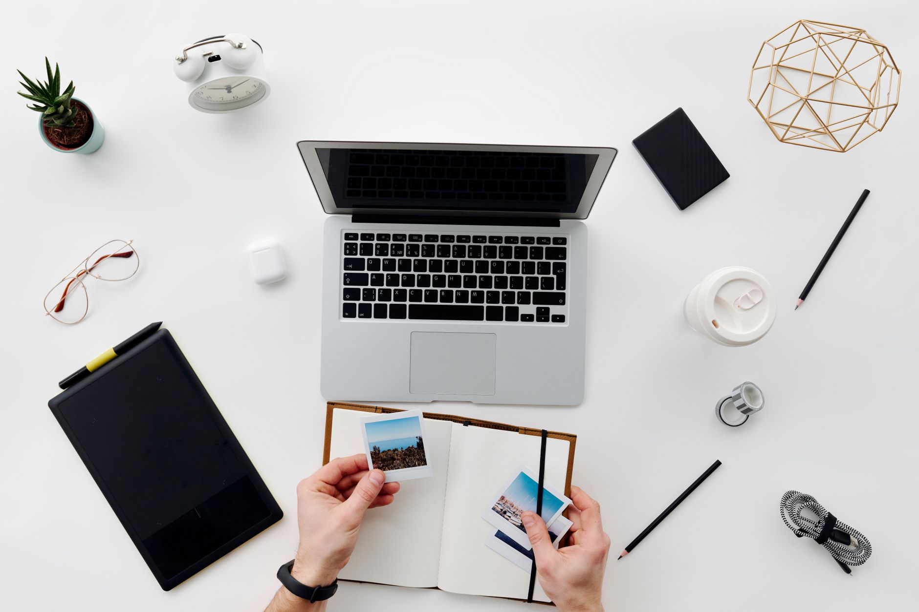 A top view of a minimalistic home office setup featuring a laptop, tablet, and accessories.