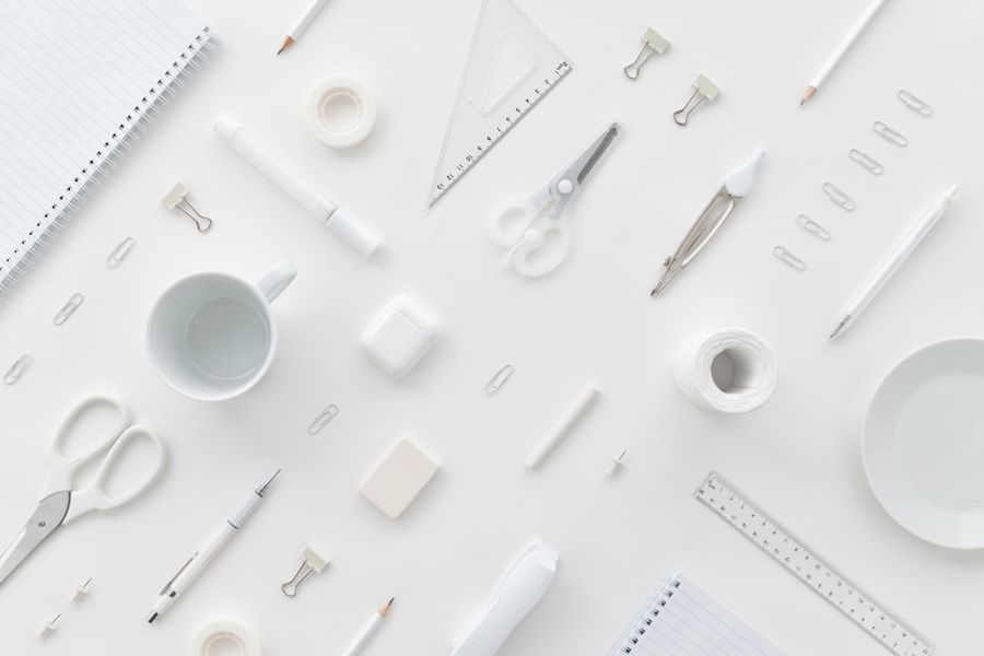 Flat lay of white desk supplies on a pale surface — photo by Luna Lovegood on Pexels