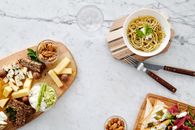 大理石表面铺着奶酪、坚果和意大利面，非常适合美食爱好者