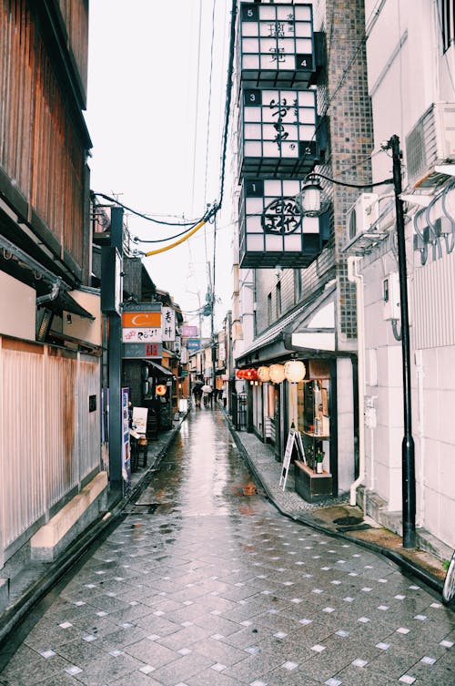 Empty narrow street with shops in city