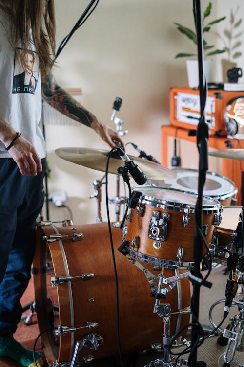 Free Woman in White Long Sleeve Shirt Playing Drum Stock Photo