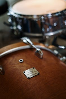 Detailed close-up of a drum set highlighting a metallic snare drum in a music studio.