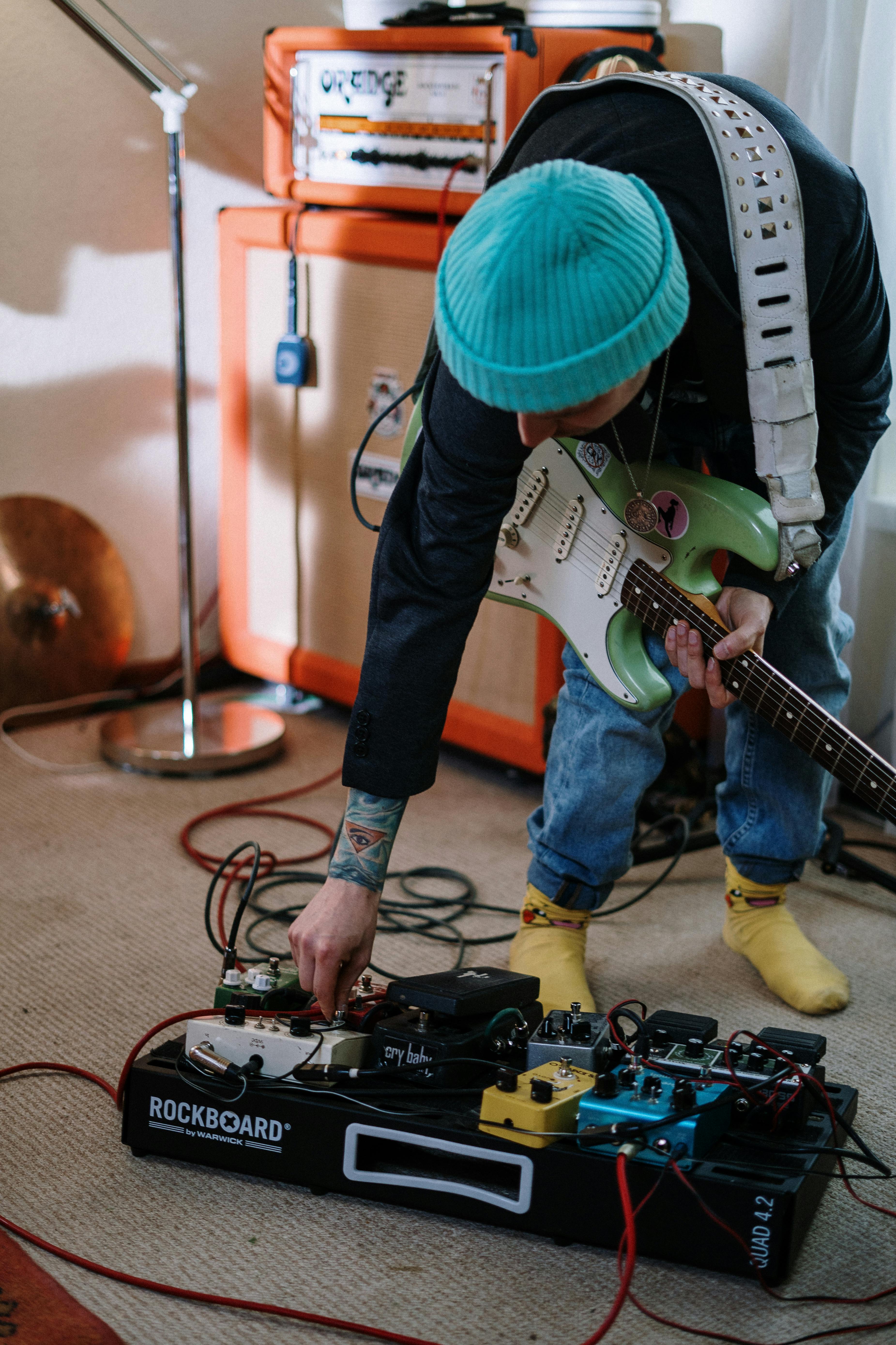 person in green hat playing electric guitar