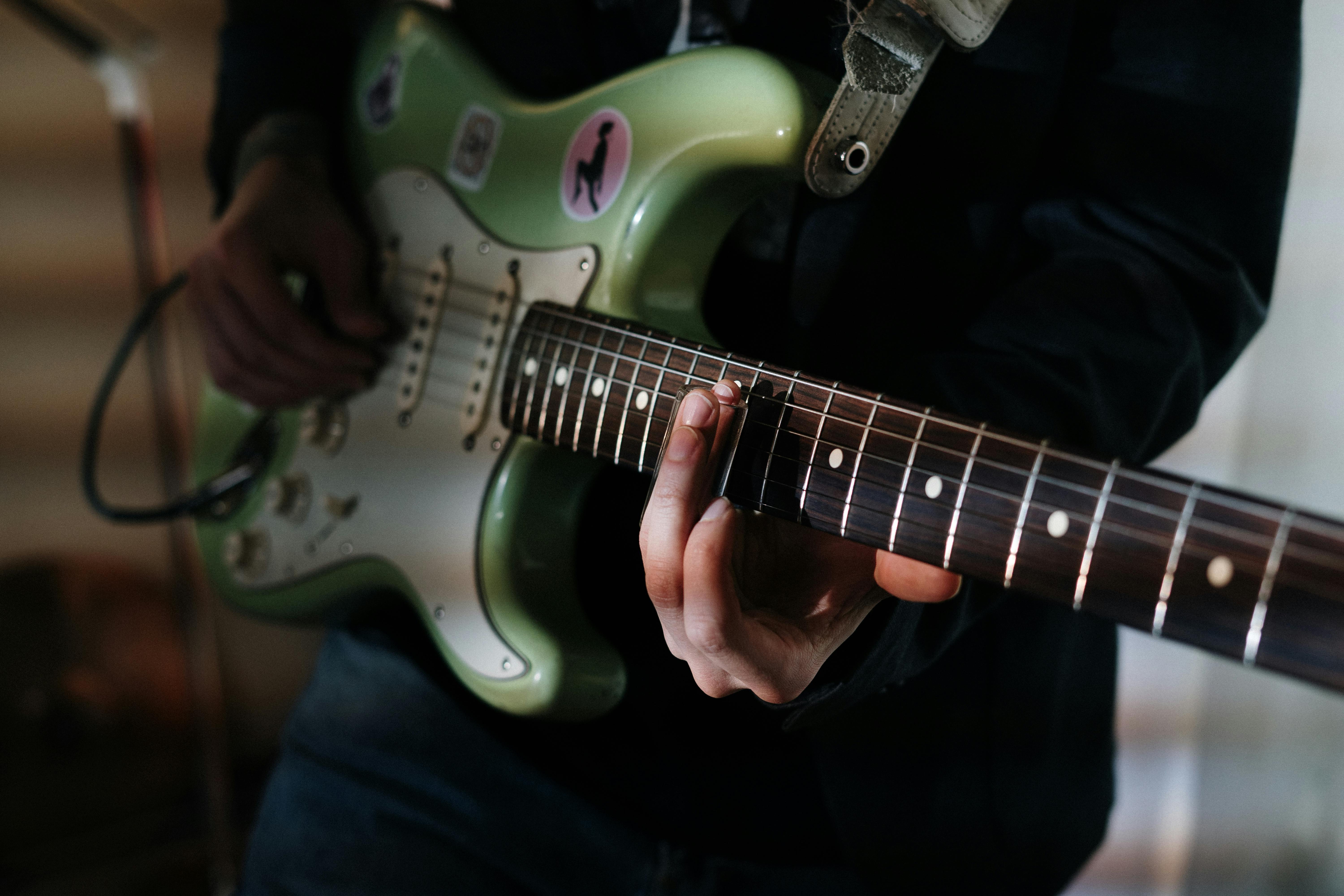 person holding white and red electric guitar