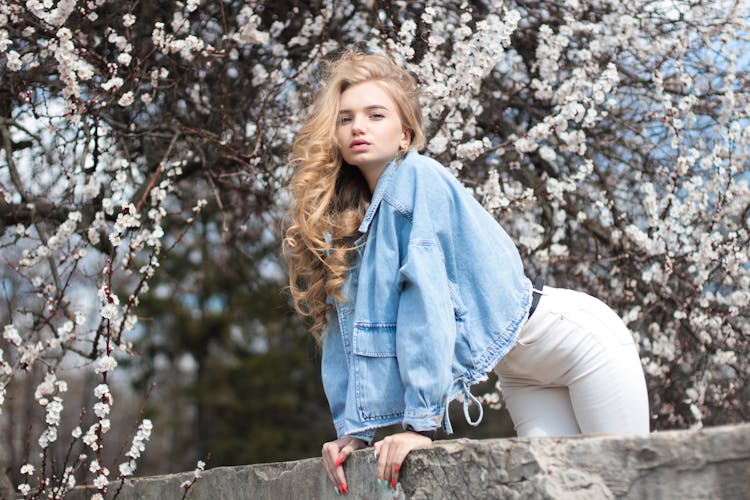 Stylish Young Female Traveler Standing In Spring Garden