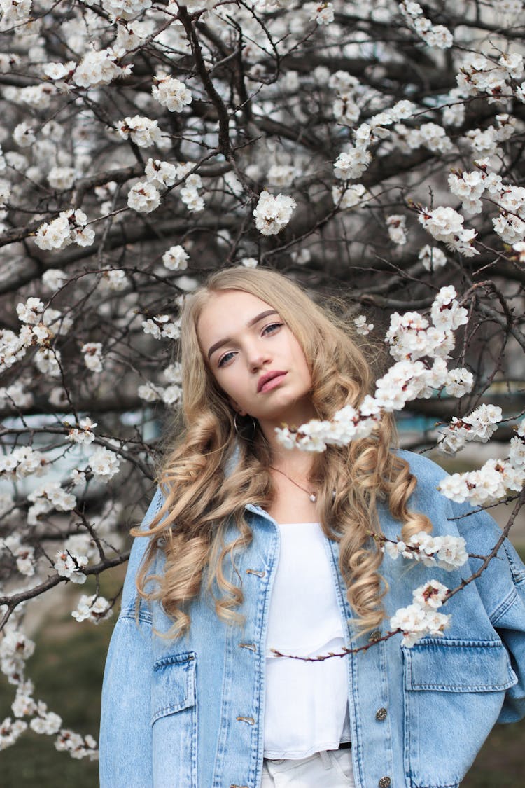 Trendy Young Woman Standing Near Blooming Tree On Spring Day