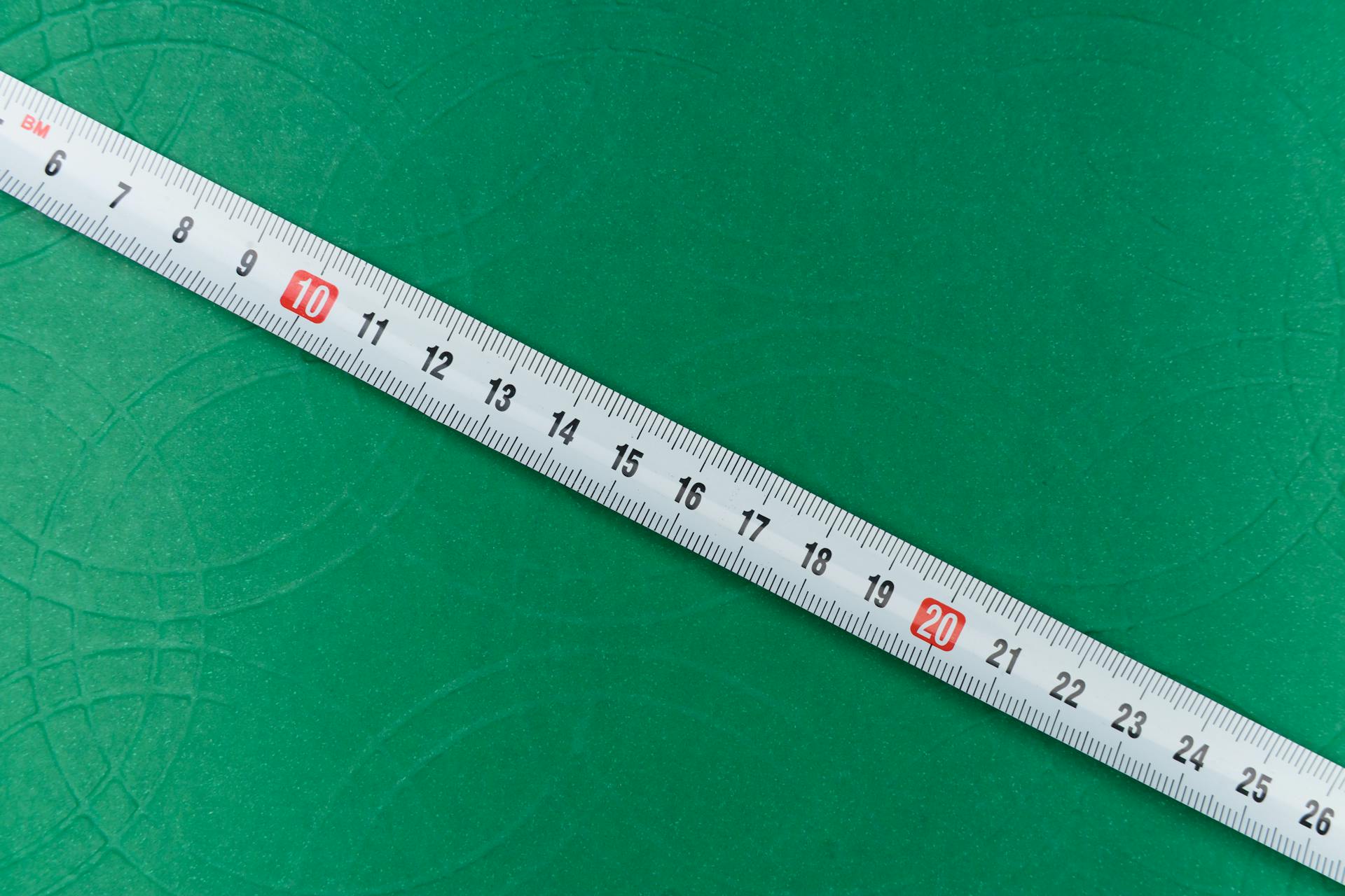 White and Black Measuring Tape on Green Background