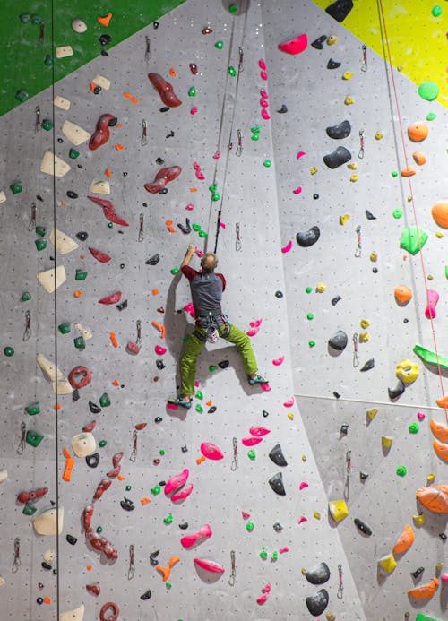 Free Unrecognizable male boulderer climbing on wall Stock Photo