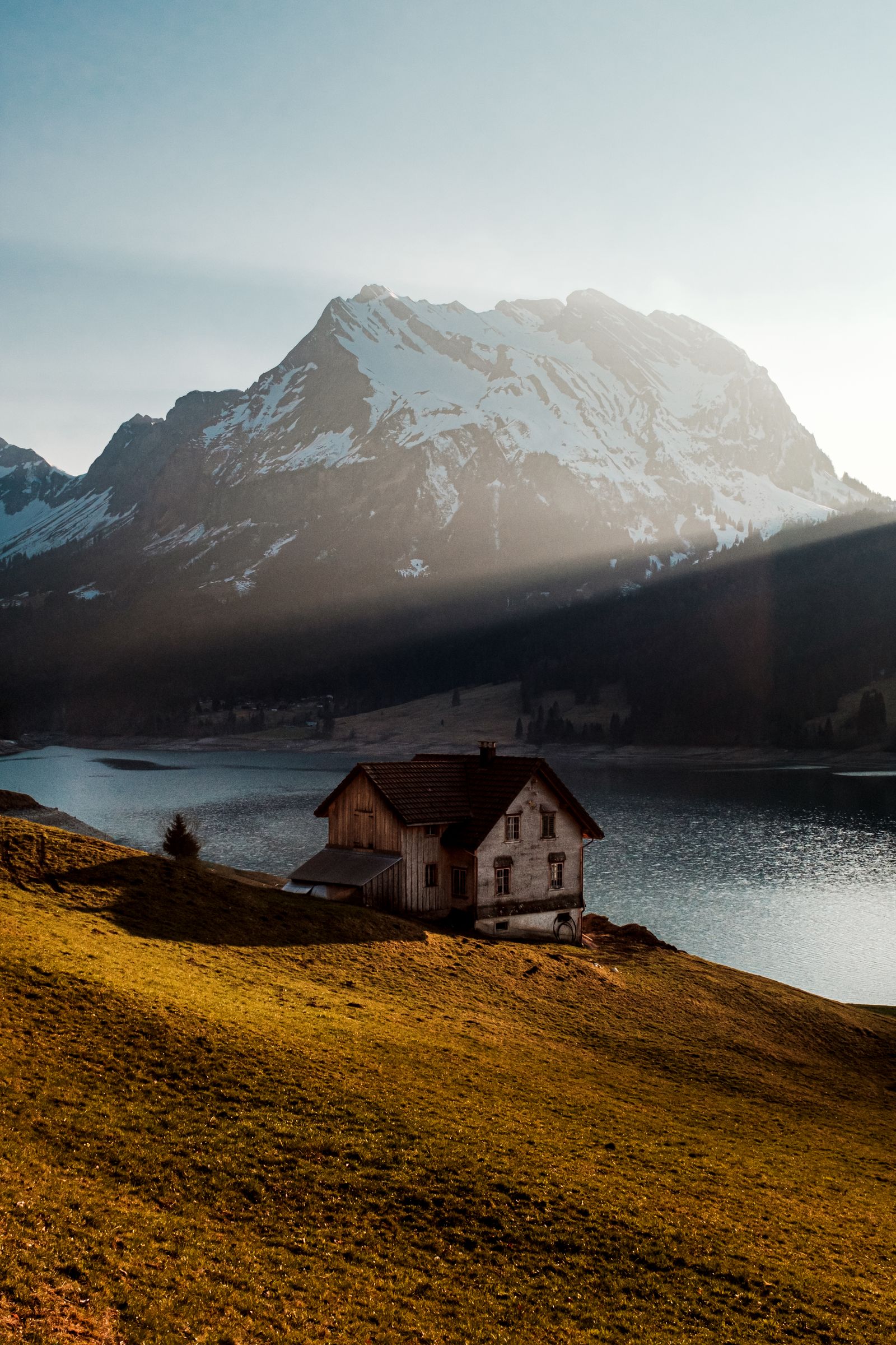 Wooden lake house exterior with mountain backdrop