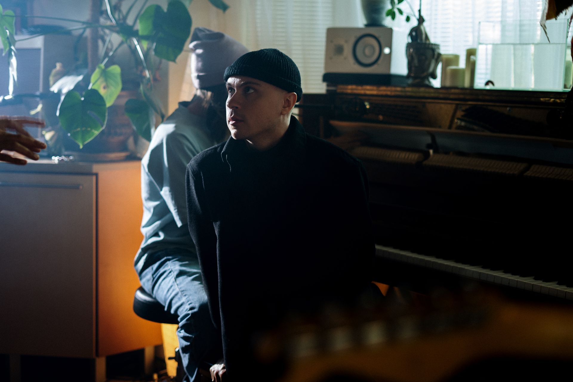 A cozy home music studio featuring a pianist and audio equipment, creating a warm ambiance.