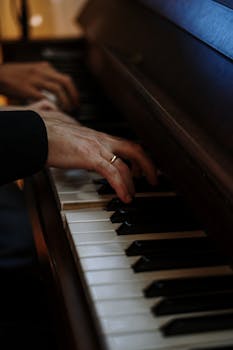 A close-up shot of fingers skillfully playing a classic grand piano keyboard.
