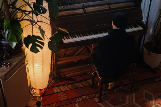 A cozy home interior featuring an upright piano, warm lighting, and a musician seated at the keyboard.