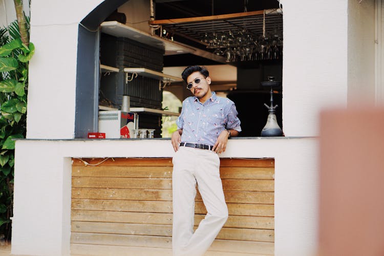 Trendy Young Indian Man Resting Near Counter Of Summer Cafe