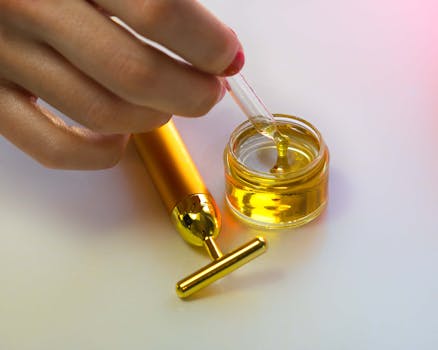 Close-up of a hand handling a serum dropper with massage tool showcasing luxury skincare routines.