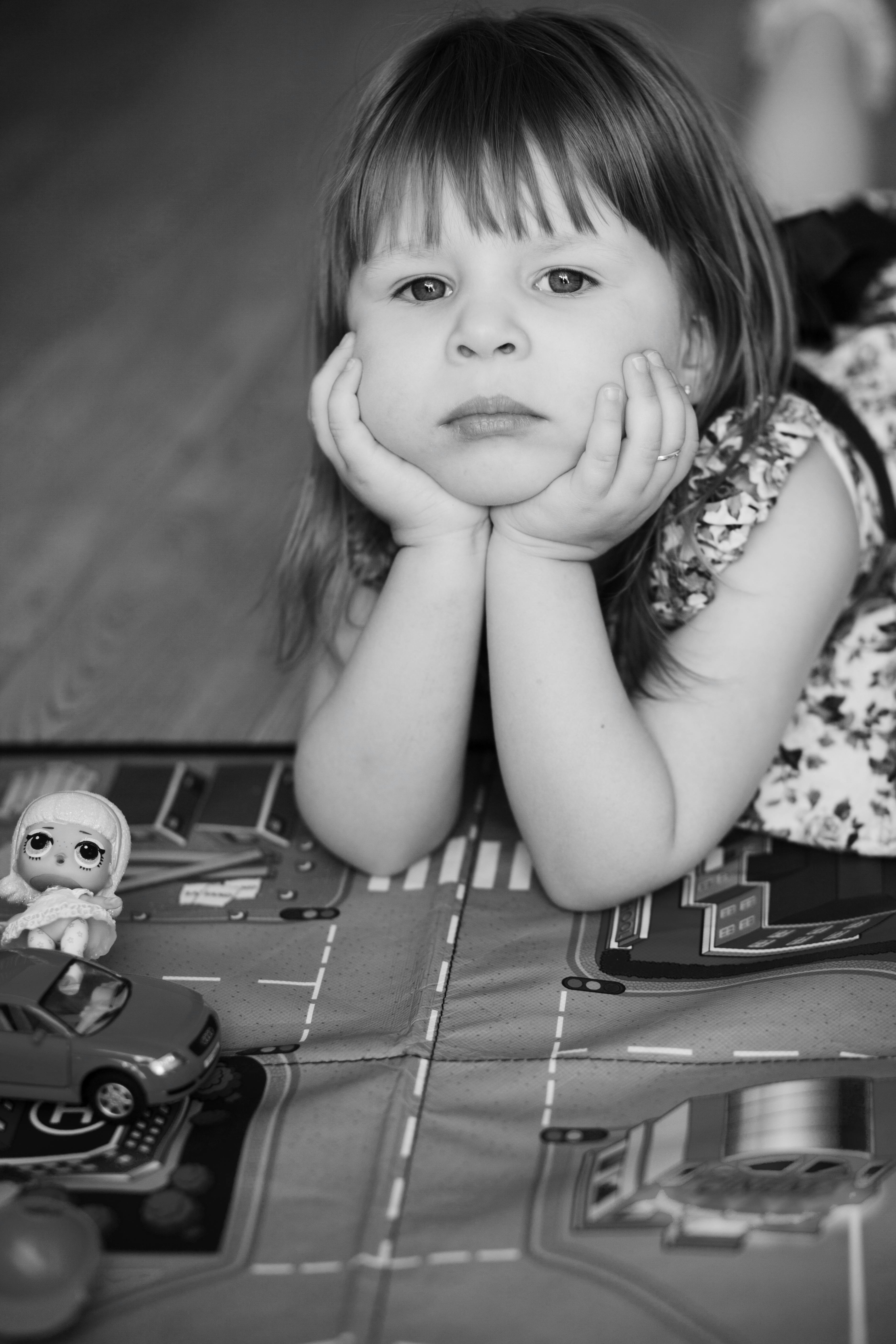 grayscale photo of girl lying on floor