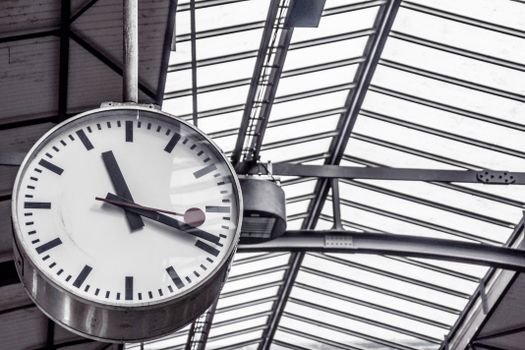 A detailed view of a large clock inside a modern railway station.
