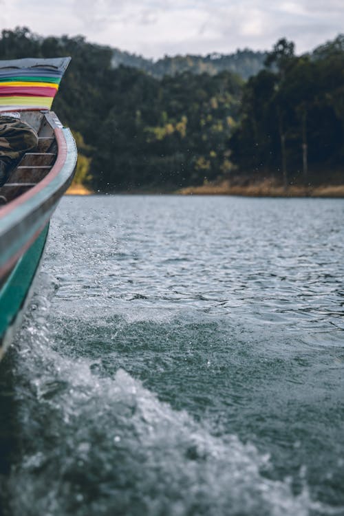 Detail of old traditional fishing floating on lake surrounded by green lush trees on rainy day