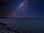 夜晚，在宁静的海面上，可以欣赏到银河系的壮丽景色，海岸边岩石丛生