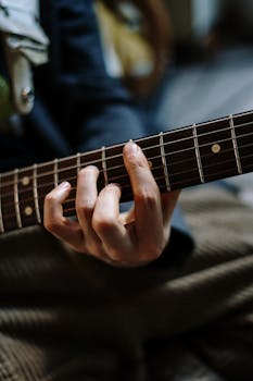 Detailed shot of a person playing an electric guitar, capturing the essence of live music performance.