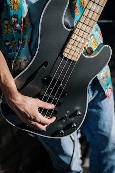 Musician playing electric guitar in a casual setting, wearing a colorful shirt.