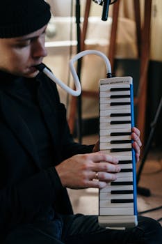 Close-up of a musician playing a melodica, capturing the essence of music creation in a cozy home studio.
