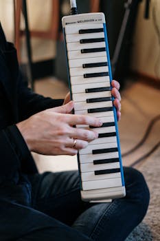 A musician plays a Suziki Melodion M-37C indoors, capturing a detailed and artistic moment.