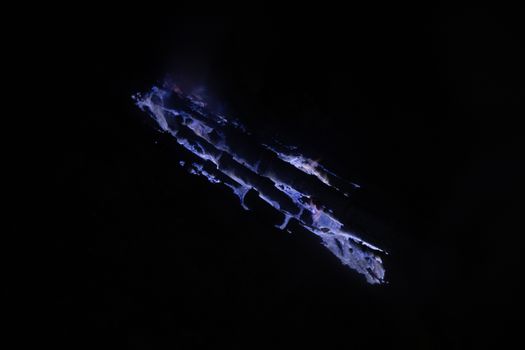 Blue flames in volcano crater at night