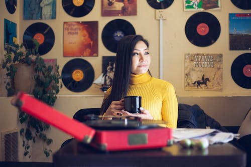 Young Asian woman lounging and drinking coffee