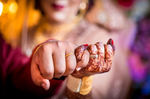 Free A close-up shot capturing a bride and groom's hands with henna at a traditional wedding. Stock Photo