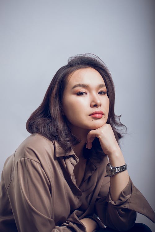 Serious well dressed woman on gray background