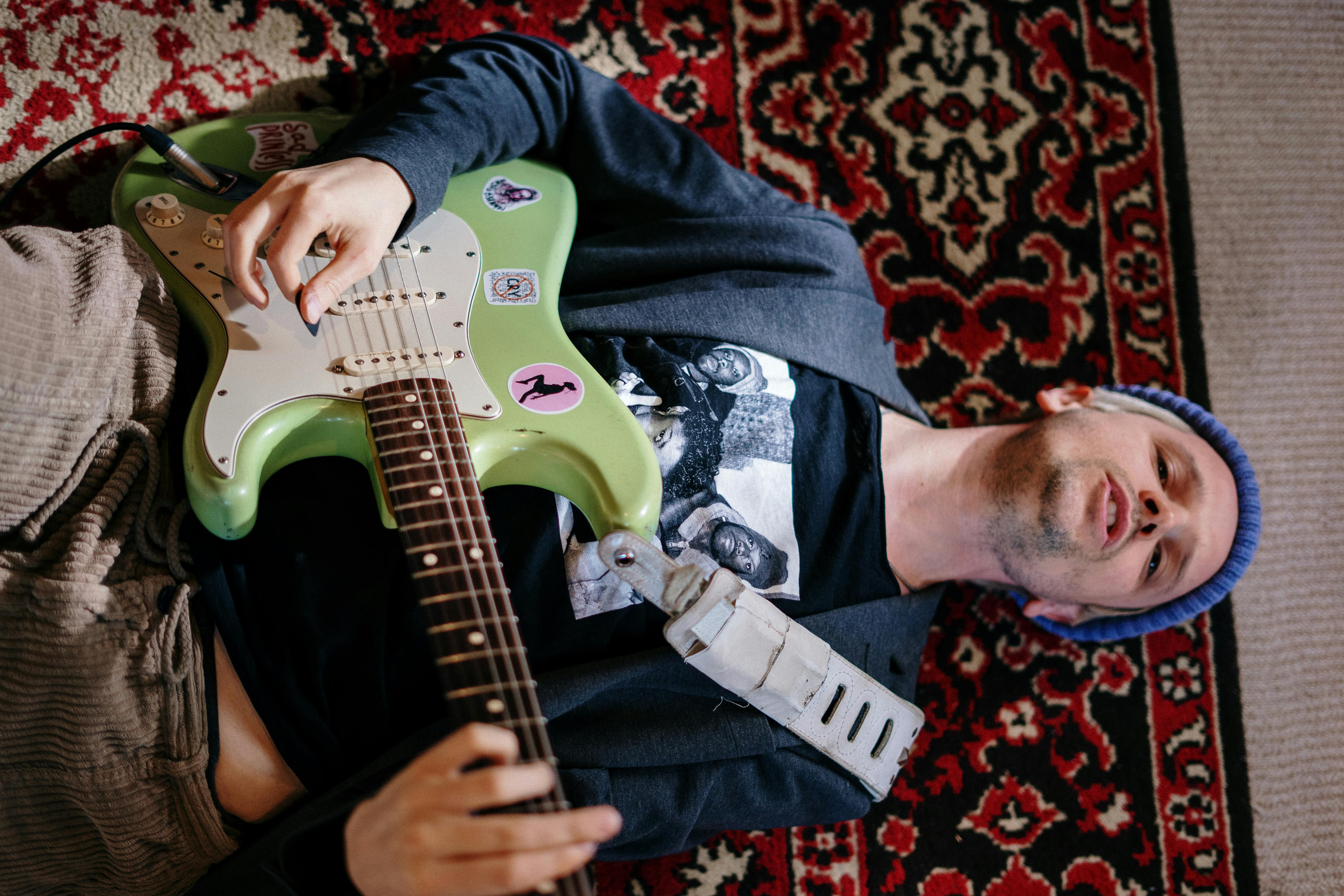 man in gray and black plaid button up shirt playing electric guitar