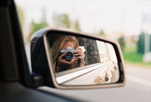 Person Taking a Self Portrait on a Rear View Mirror