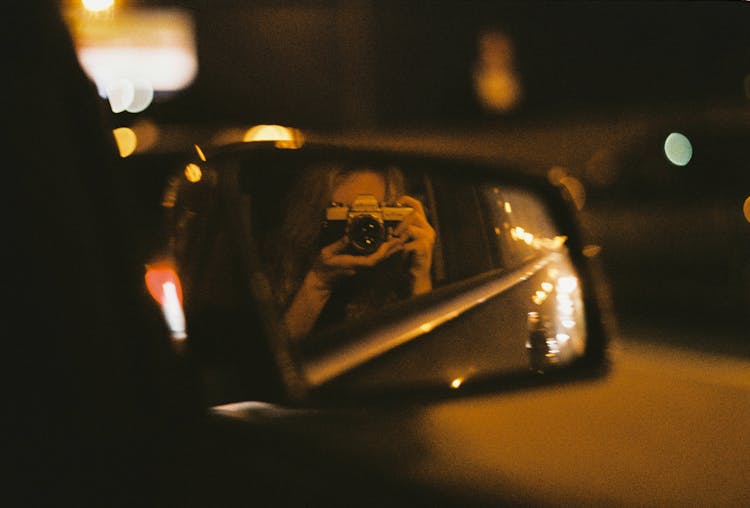 Person Taking A Self Portrait On A Rear View Mirror